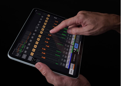 Hands using the DM StageMix iPad app to remotely control a Yamaha DM5